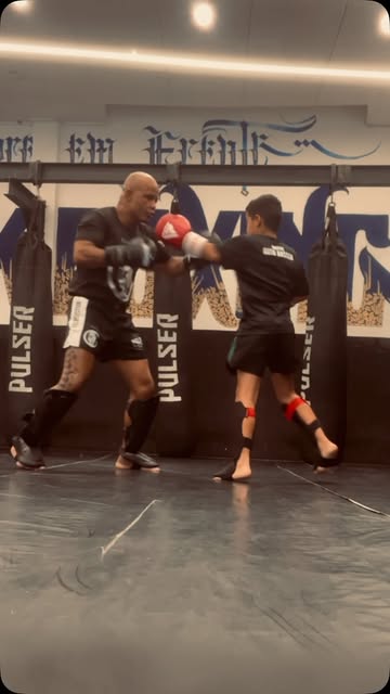 Aluno jovem treinando socos com o mestre
